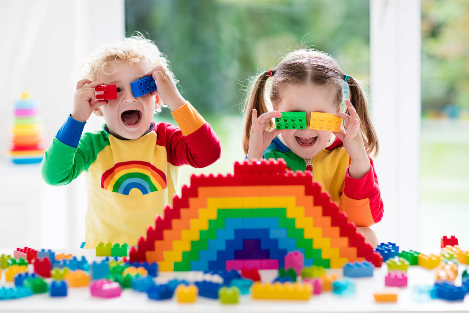 Zwei Kinder spielen mit bunten Bausteinen