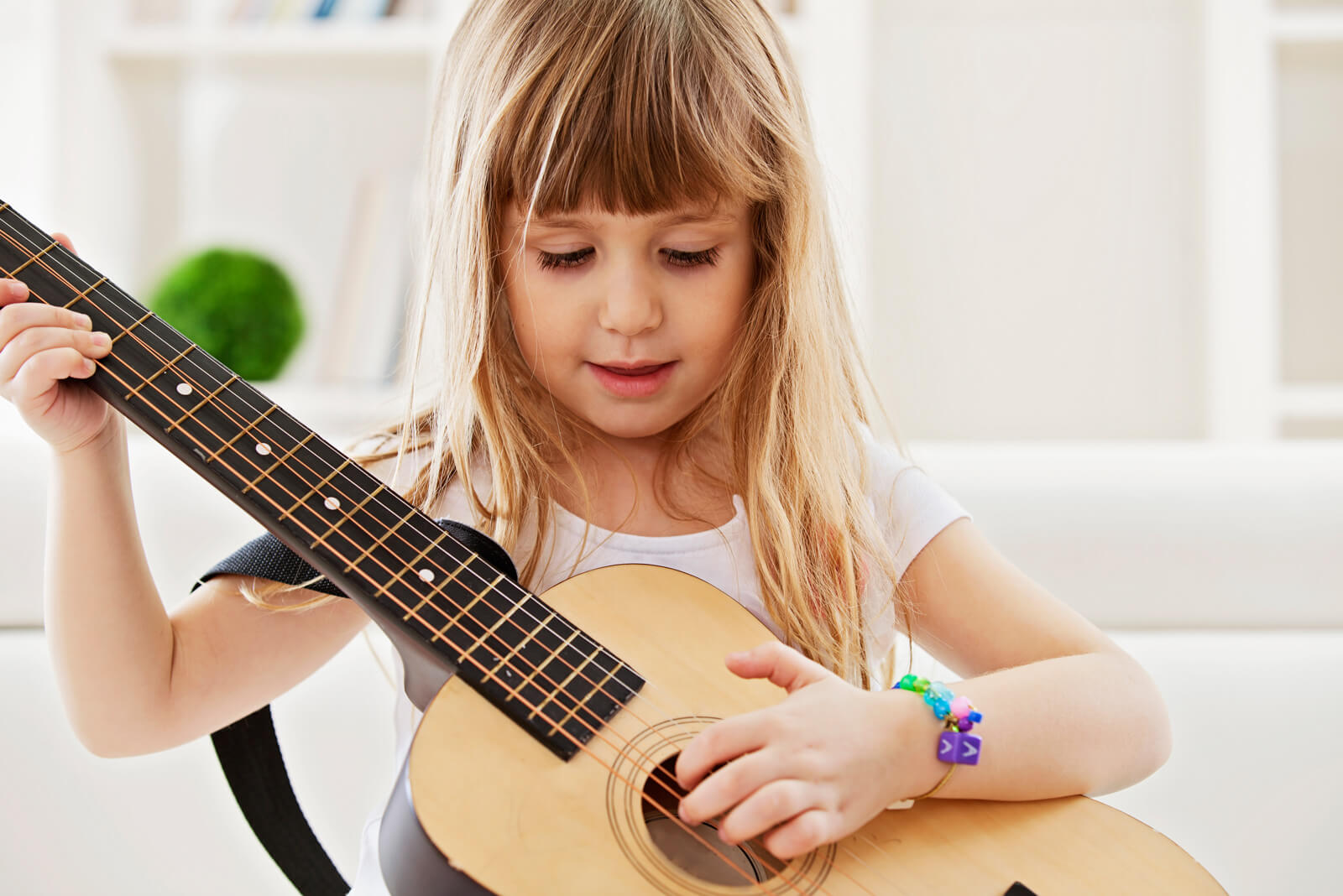 Kleines Mädchen spielt auf der Gitarre