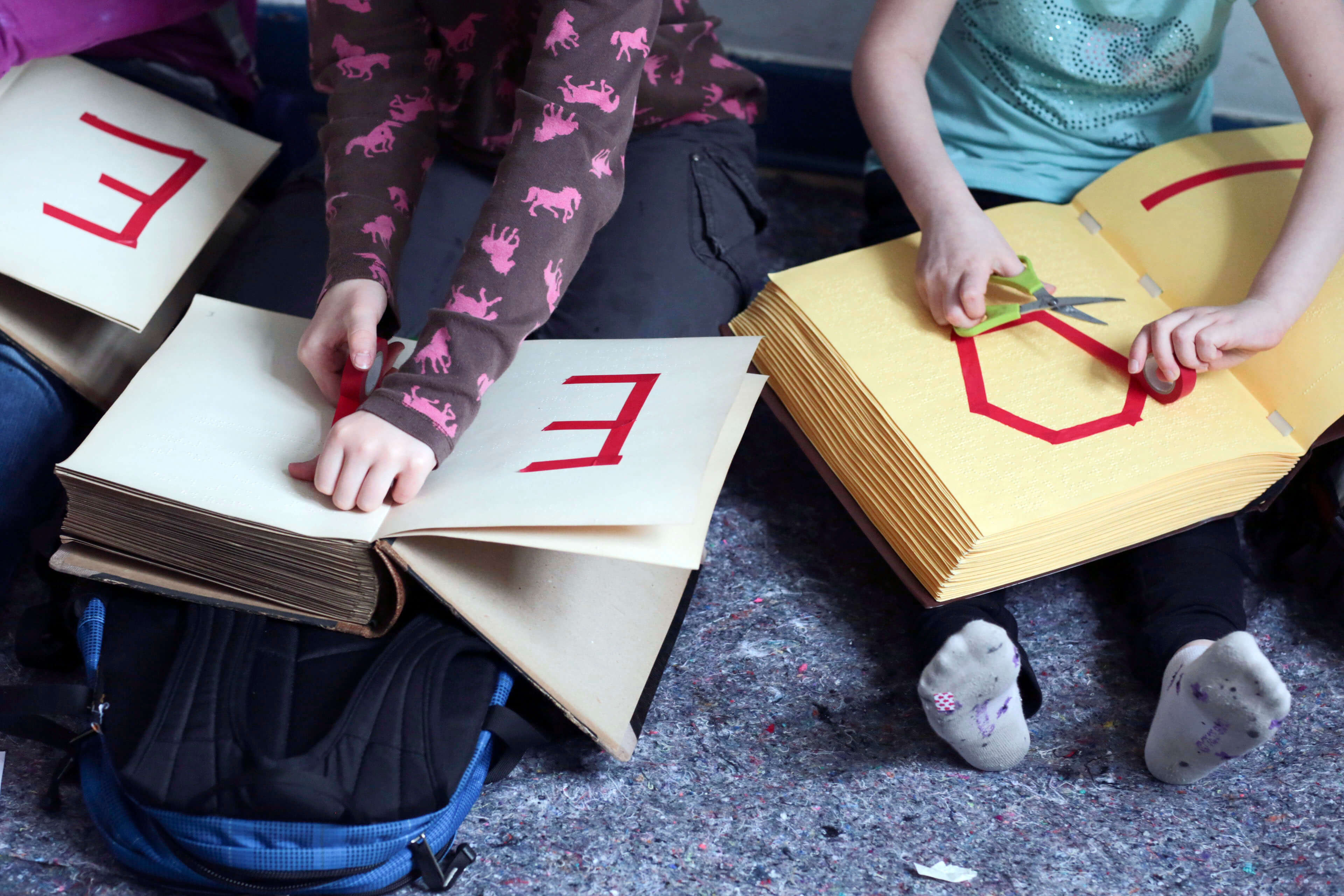 Kinder kleben Buchstaben in Bücher