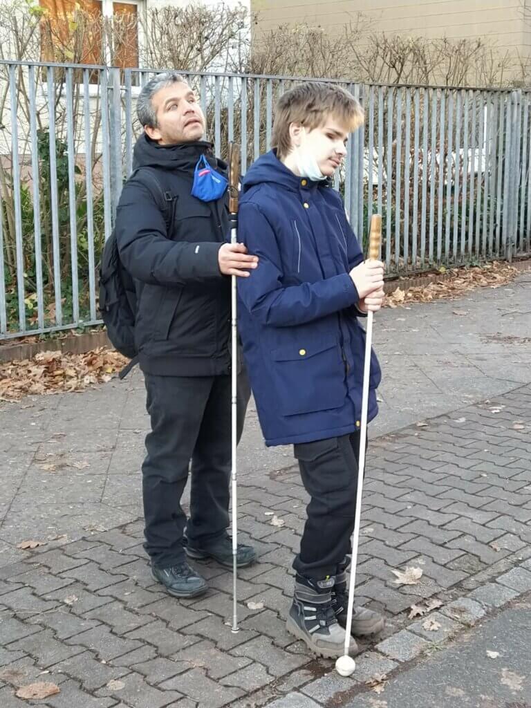 Ein Schüler mit Juan Ruiz auf dem Gehweg